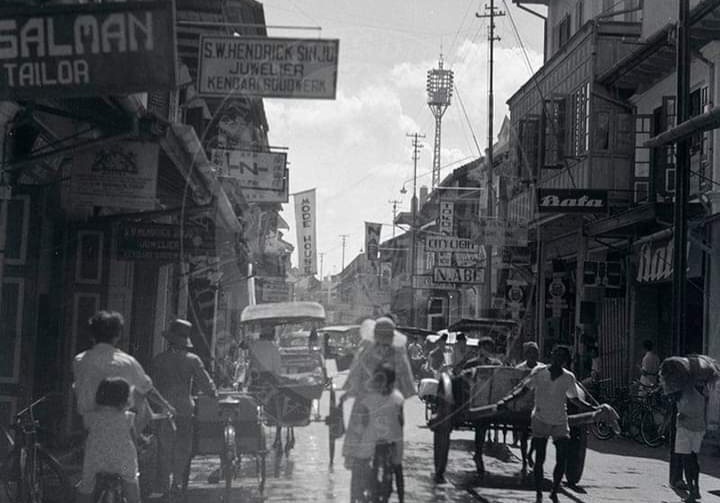 Suasana Passerstraat (sekarang Jalan Nusantara), 1938. Terlihat sejumlah toko seperti Salman Tailor, S.W. Hendrick Sinjo, Bata, Kong Hing, N. Abe & Co., dan Japan. Sebuah tiang listrik di Muurstraat (sekarang Jalan Timor) juga tampak menjulang tinggi (Foto : Istimewa)